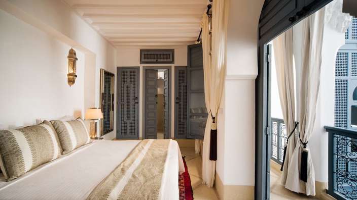 Ein Schlafzimmer mit einem großen Bett und einem Balkon