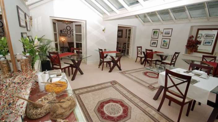 Ein Esszimmer mit vielen Tischen und Stühlen