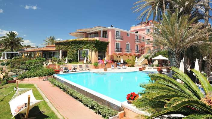 Ein großer Pool mit einem rosa Gebäude im Hintergrund