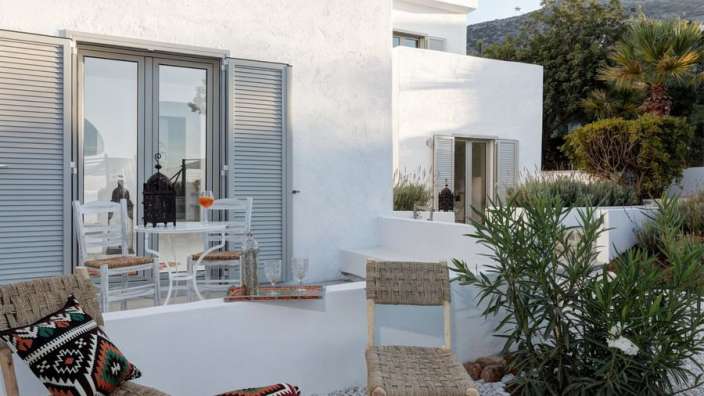 Ein weißes Haus mit einem Tisch und Stühlen davor