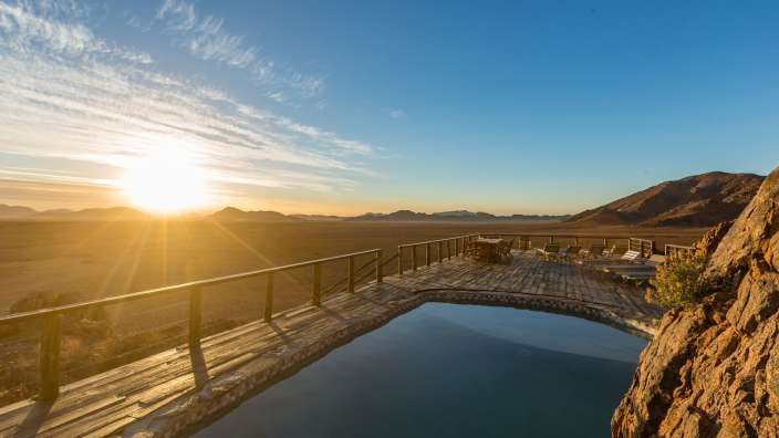 Ein Swimmingpool mit Blick auf die Wüste bei Sonnenuntergang