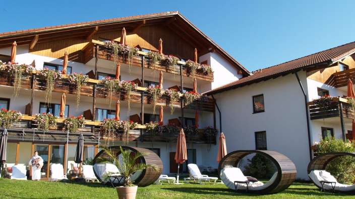 Eine Frau steht vor einem Hotel mit vielen Balkonen