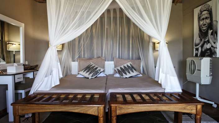 Ein Bett mit weißen Vorhängen und einem Bild an der Wand