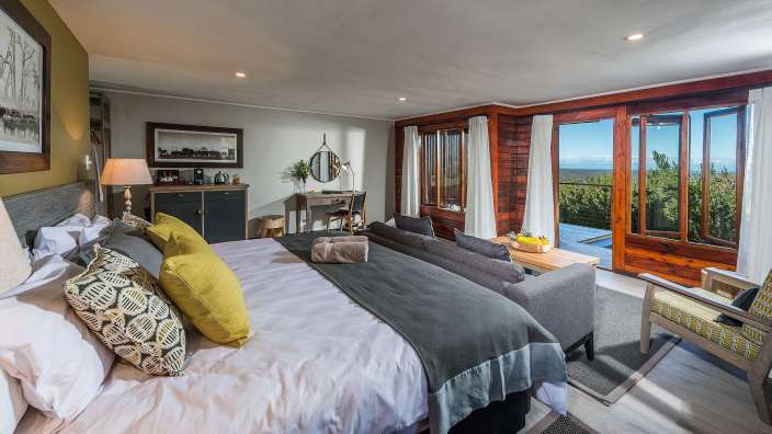 Ein Schlafzimmer mit einem großen Bett und vielen Fenstern