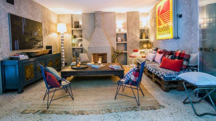 Ein Wohnzimmer mit vielen Möbeln und einem kodak-Logo an der Wand