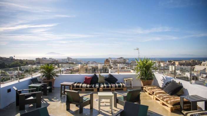 Eine Terrasse mit Stühlen und einem Tisch mit Blick auf das Meer