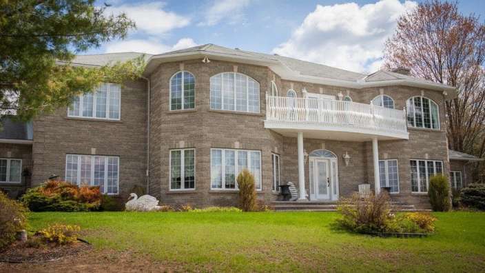 Ein großes Backsteinhaus mit vielen Fenstern und einem Balkon