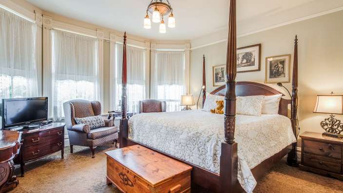 Ein Schlafzimmer mit einem Himmelbett und einem Fernseher