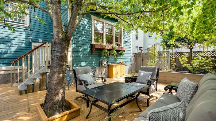 Ein Wohnzimmer mit einer Couch und Stühlen auf einem Holzdeck