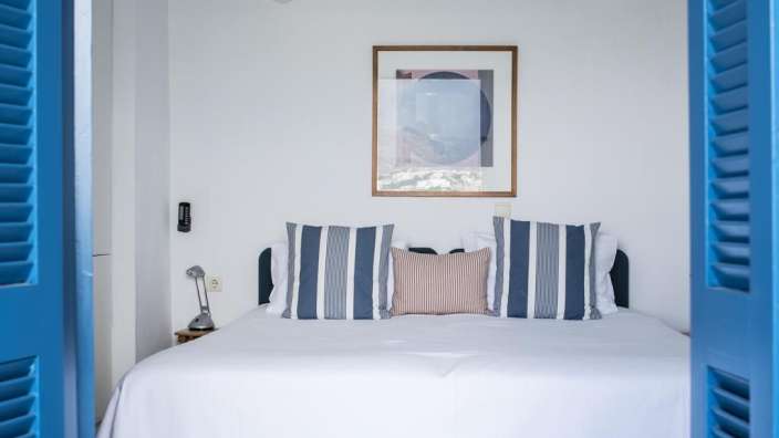 Ein Schlafzimmer mit einem Bett und blauen Fensterläden