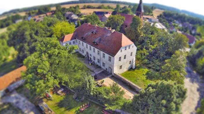 Eine Luftaufnahme eines großen Gebäudes mit einer Kirche im Hintergrund