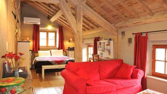 Ein Wohnzimmer mit einem roten Sofa und einem Bett