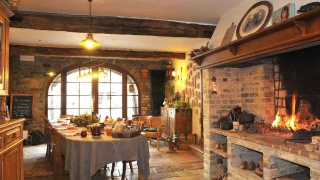 Ein Esszimmer mit einem Tisch und Stühlen und einem Kamin