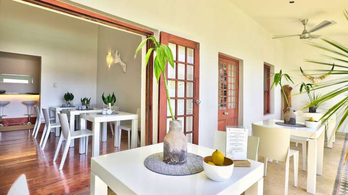 Ein Speisesaal mit weißen Tischen und Stühlen