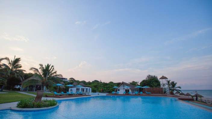 Ein großer Swimmingpool mit einem weißen Gebäude im Hintergrund