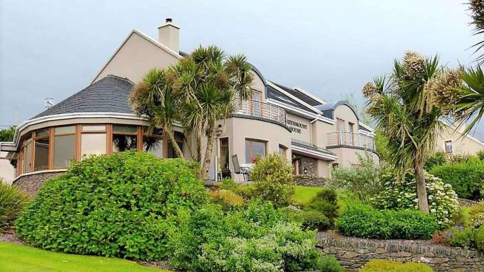 Ein großes weißes Haus mit einem schwarzen Schild darauf