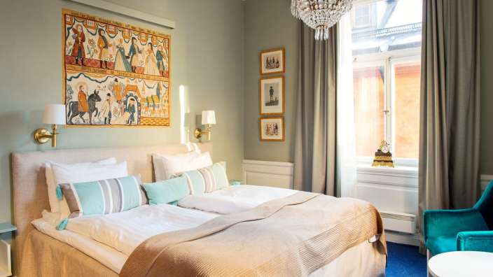 Ein Schlafzimmer mit einem Bett und einem Gemälde an der Wand