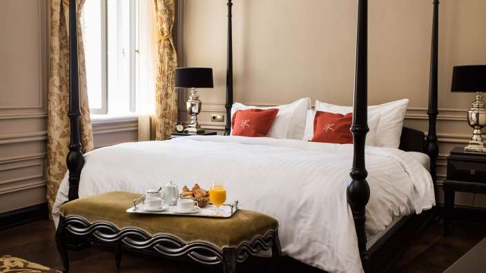 Ein vierposterbett mit einem tablett mit frühstück darauf