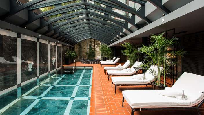 Ein Innenpool mit Liegestühlen und einem Glasdach