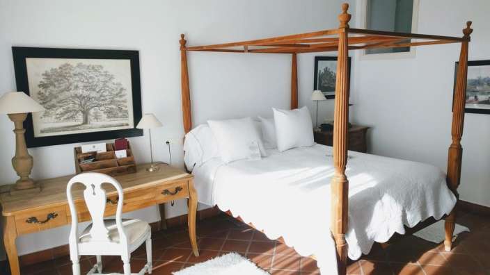 Ein Schlafzimmer mit einem Himmelbett und einem Schreibtisch