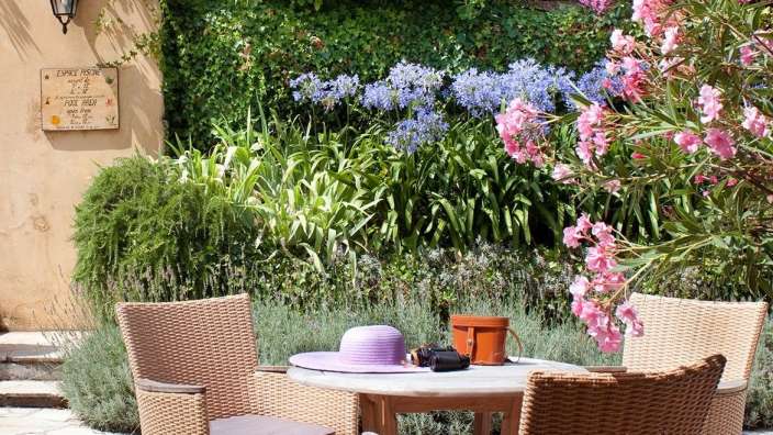 Ein Tisch und Stühle in einem Garten mit einem Schild darüber