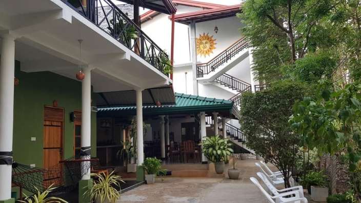 Ein grünes und weißes Gebäude mit einer Sonnenblume darauf