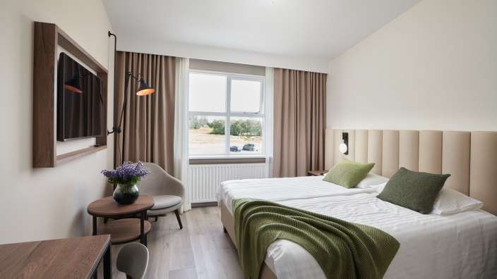 Ein Hotelzimmer mit zwei Betten und einem Fernseher