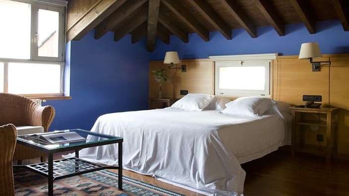 Ein Schlafzimmer mit blauen Wänden und einem weißen Bett