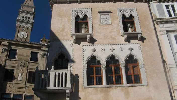 Ein sehr altes Gebäude mit vielen Fenstern und einem Balkon