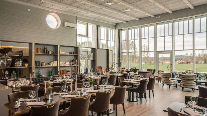 Ein großes Esszimmer mit vielen Tischen und Stühlen