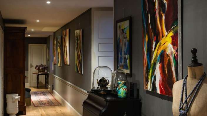 Ein Flur mit vielen Gemälden an der Wand