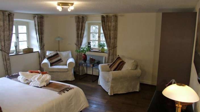 Ein Schlafzimmer mit einem Bett und zwei Stühlen