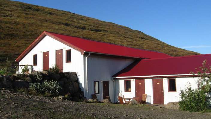 Ein kleines weißes Haus mit einem roten Dach