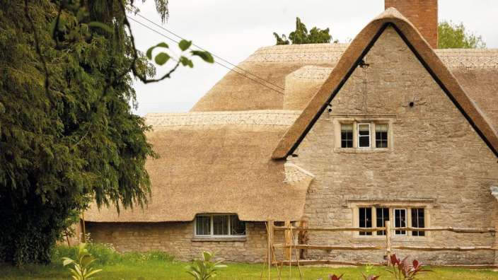 Ein strohgedecktes Haus mit vielen Fenstern