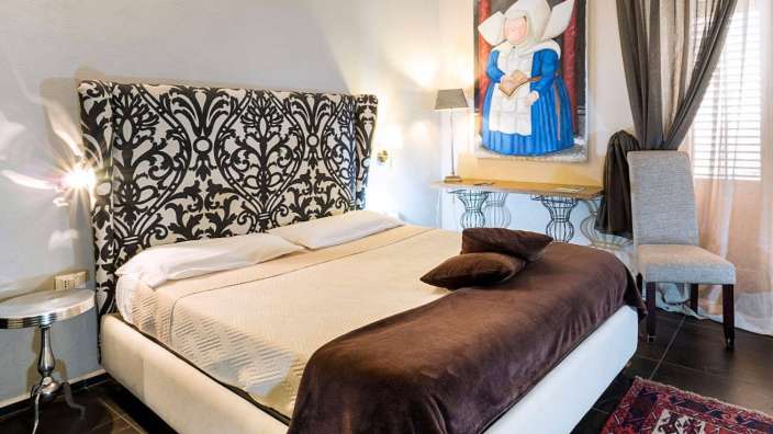 Ein Schlafzimmer mit einem Bett und einem Gemälde an der Wand