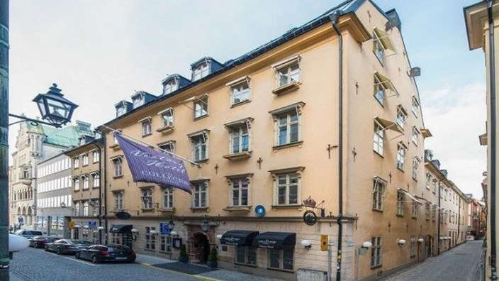 Ein großes Gebäude mit vielen Fenstern und einer Fahne davor .