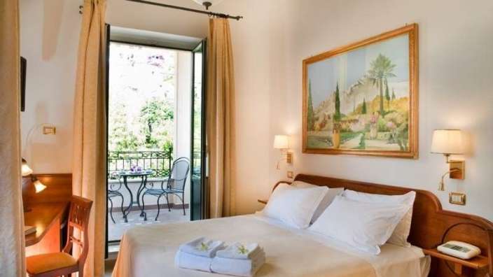 Ein Hotelzimmer mit einem Bett und einem Gemälde an der Wand