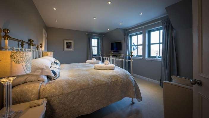 Ein Schlafzimmer mit einem Bett und zwei Fenstern