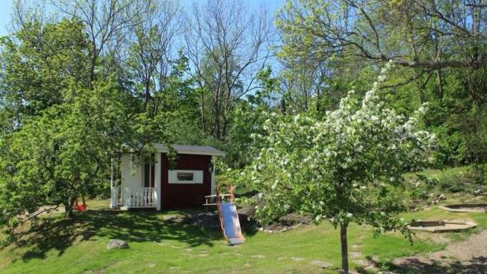 Ein rot-weißes Spielhaus mit einer Rutsche davor