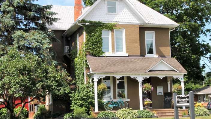 Ein großes Backsteinhaus mit einem blauen Fahrrad auf der Veranda