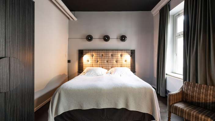 Ein kleines Schlafzimmer mit einem Bett und einem Stuhl