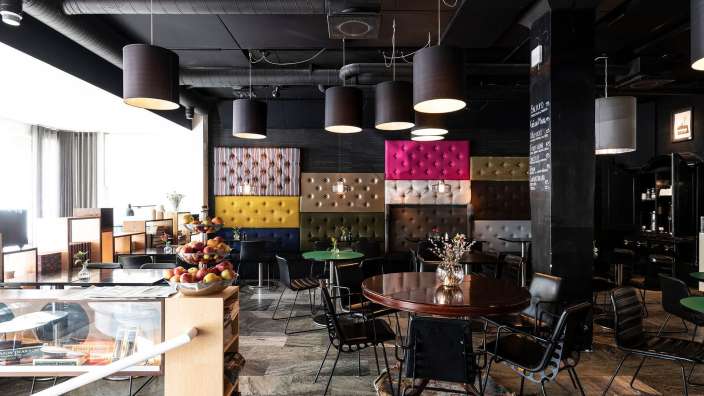 Ein Speisesaal mit Tischen und Stühlen und einer Tafel mit einem Menü darauf