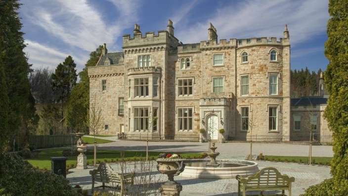 Ein großes Steingebäude mit einem Brunnen davor