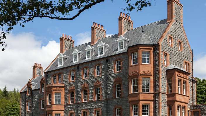 Ein großes Steingebäude mit vielen Fenstern und Schornsteinen