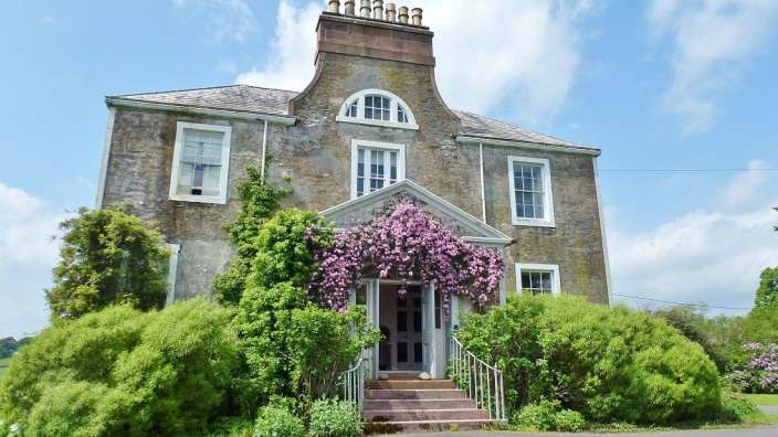 Ein großes Steinhaus mit einem roten Schornstein