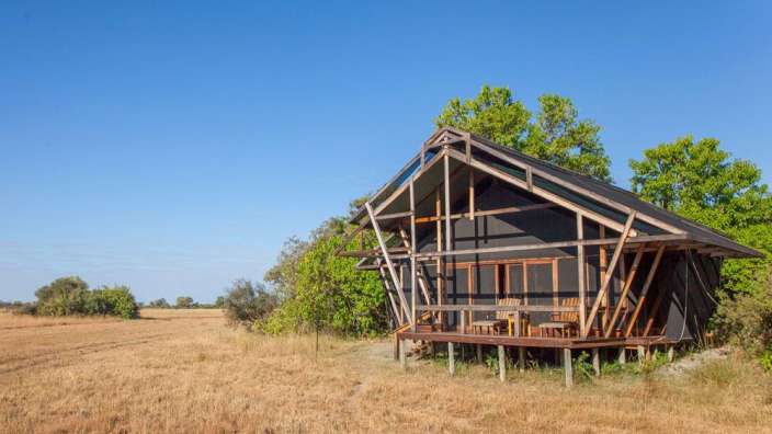 Ein kleines Haus auf Stelzen in einem Feld