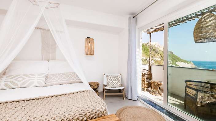 Ein weißes Schlafzimmer mit einem Bett und einem Stuhl