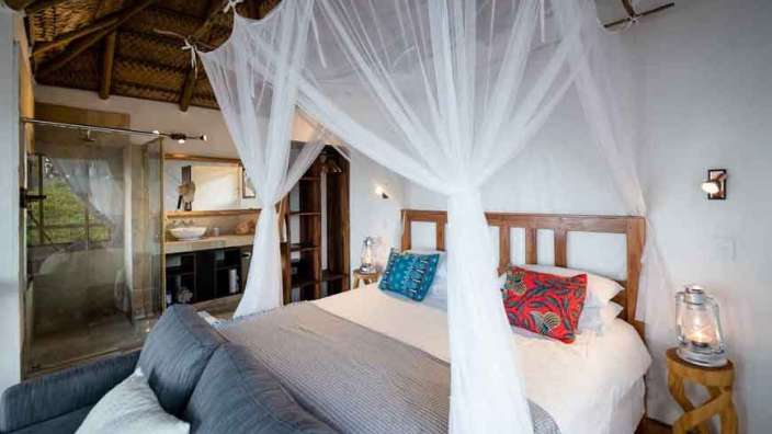 Ein Schlafzimmer mit Himmelbett, Couch und Dusche .