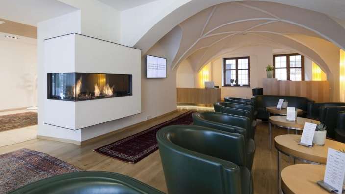 Ein Wohnzimmer mit grünen Stühlen und einem Kamin