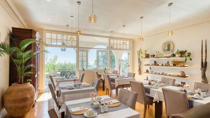 Ein Esszimmer mit vielen Tischen und Stühlen